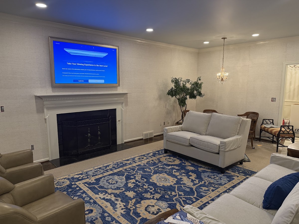 Flat-screen TV professionally mounted above a fireplace with wires concealed in a Metro Detroit living room